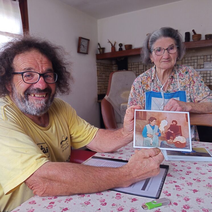 Ánchel muestra a cámara la ilustración de Javi Lavilla que refleja el momento en que su madre Generosa, mientras hilaba, le ayudaba a recopilar palabras en Belsetán.