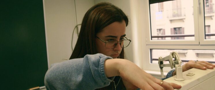 María, personaje principal del cortometraje Un día más está colocando una luz articulada mientras mira preocupada.