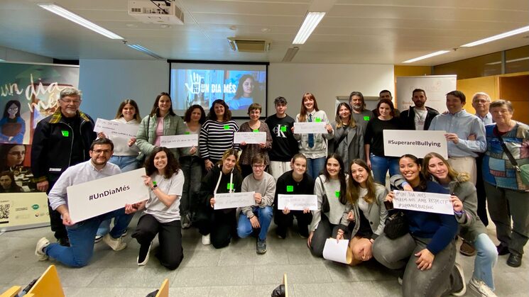 Foto de toda la gente asistente a la proyección de "Ni un dia més", compartiendo mensajes con papel, con las etiquetas #Undiamés #superarelbullying