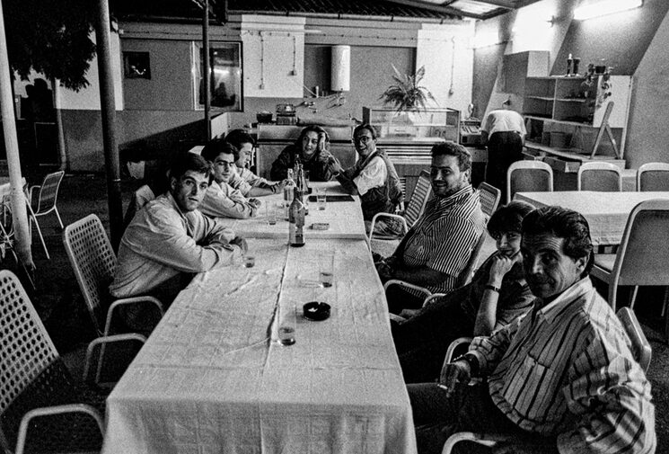 Osijek, verano de 1991. Los colegas de La Tribu, tenían la habilidad para convencer a los dueños de bares para que nos hicieran de comer: pizzas, ancas de rana, o lo que fuera, porque se pasaba hambre. En la imagen JHermann Tertsch, Julio Alonso, Eduardo, Ramón, Márquez, Ramiro Villapadierna, Arturo-Pérez Reverte... en la que pudo ser la última cena. Estaban bombardeando y nosotros a lo nuestro, a por las ancas de rana y Arturo viendo el percal que se aproximaba dijo: Esperamos a la tercera y salimos corriendo". Y así fue, la granada no explotó y salimos todos como pudimos, nos tiramos al suelo, y al día siguiente no quedaba nada del restaurante.
