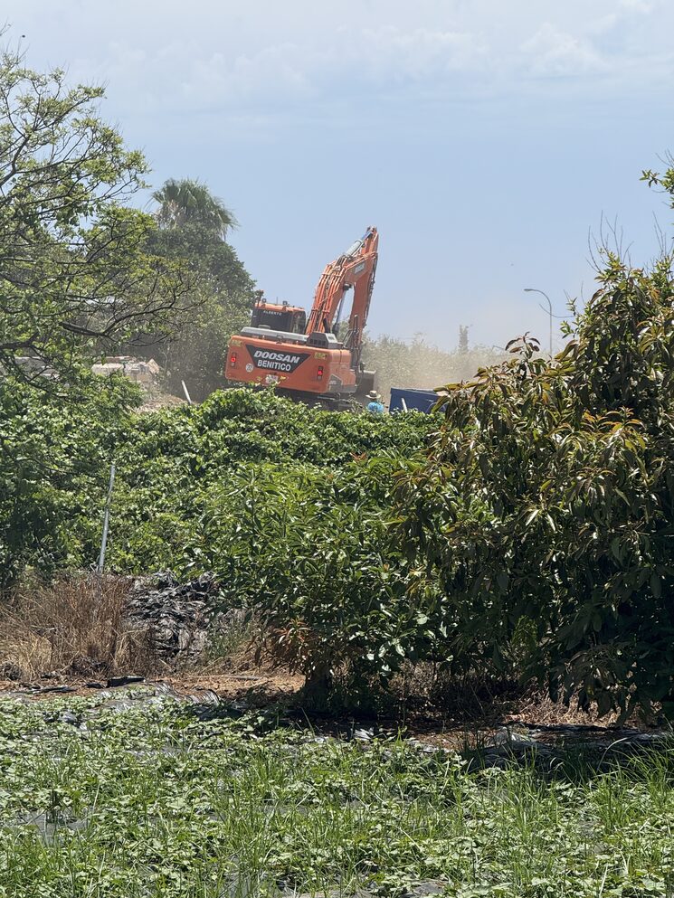 Excavation machine demolishing a finca
