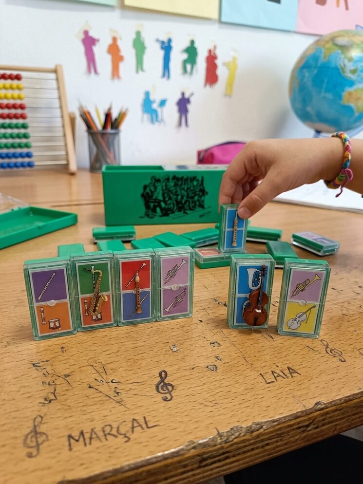 Joc físic del domino de la cobla amb instruccions per jugar en equip.